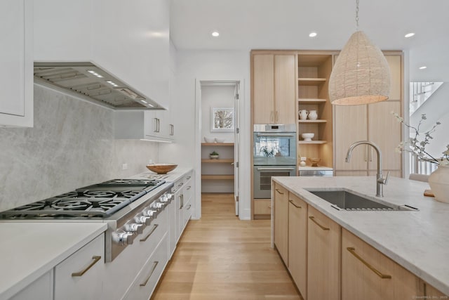 kitchen featuring white cabinets, sink, hanging light fixtures, and stainless steel appliances