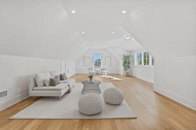 living area featuring lofted ceiling and light hardwood / wood-style flooring