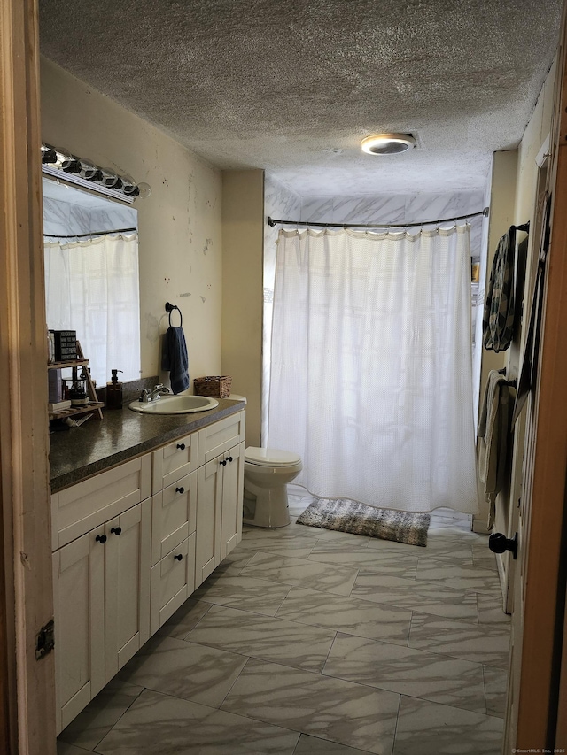 bathroom with vanity, a textured ceiling, and toilet