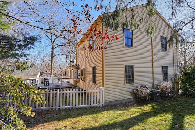 view of property exterior with central AC, a yard, and a deck