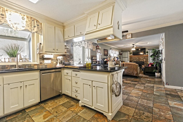 kitchen with black cooktop, a brick fireplace, sink, cream cabinets, and dishwasher