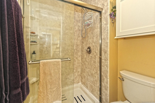 bathroom with toilet and a shower with shower door