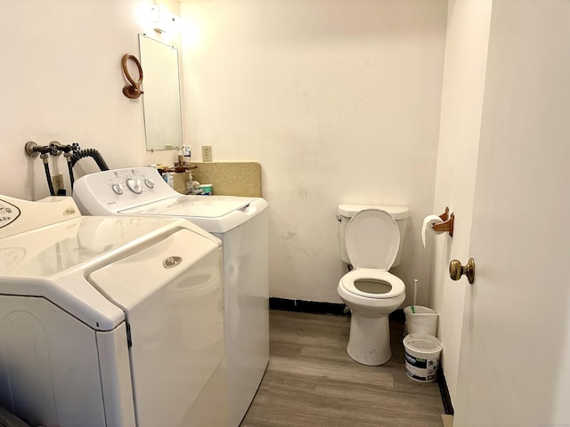 laundry area with washer and clothes dryer and light hardwood / wood-style flooring