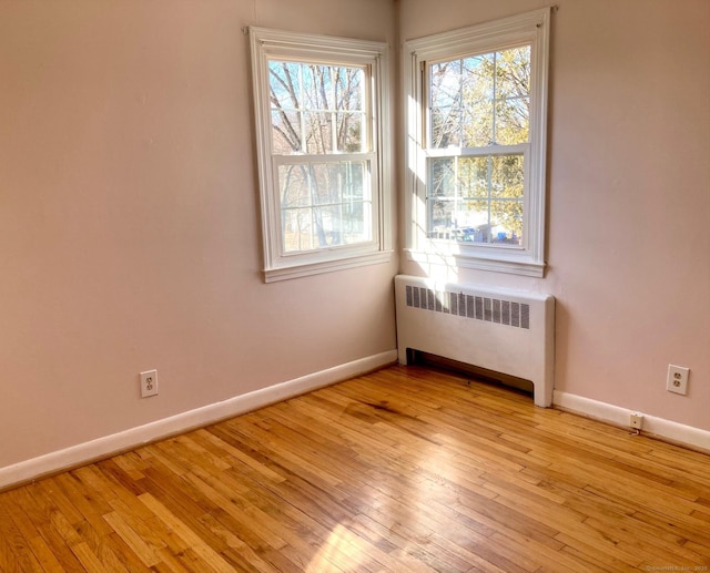 spare room with light hardwood / wood-style flooring and radiator