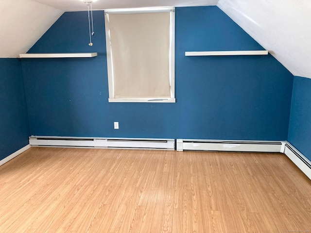 additional living space with hardwood / wood-style flooring, baseboard heating, and lofted ceiling