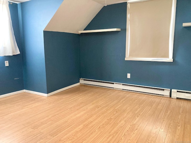 interior space featuring a baseboard radiator, lofted ceiling, and hardwood / wood-style flooring