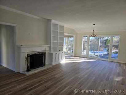 unfurnished living room featuring dark hardwood / wood-style floors and a notable chandelier