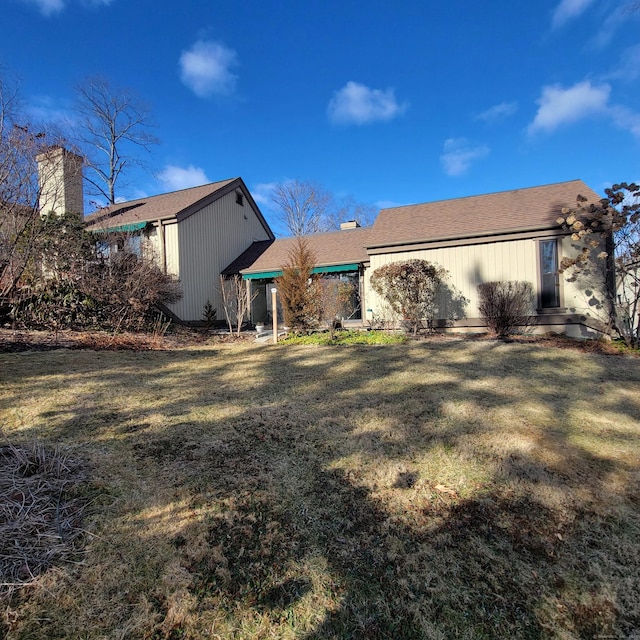 rear view of property featuring a lawn