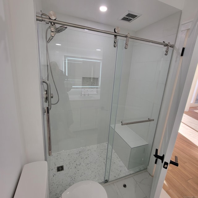 bathroom with toilet and an enclosed shower