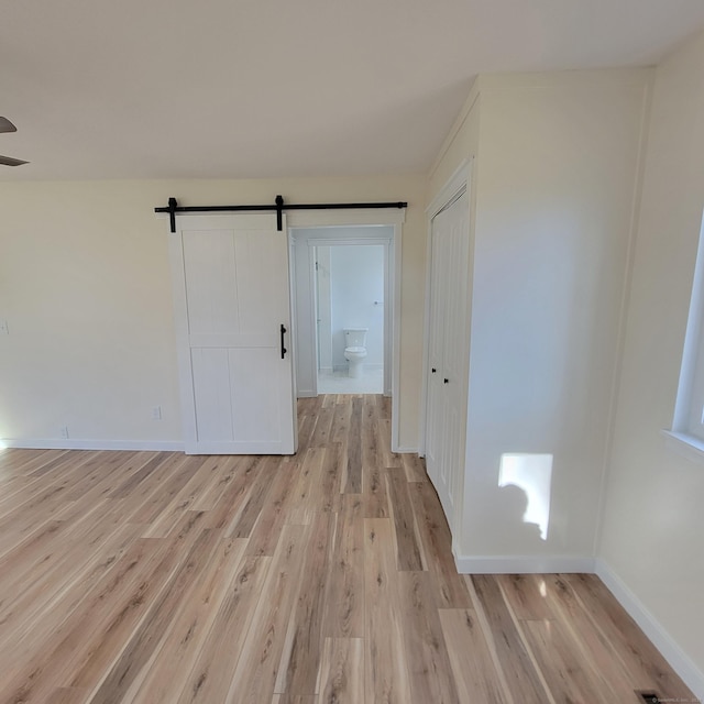 empty room featuring light hardwood / wood-style flooring and a barn door