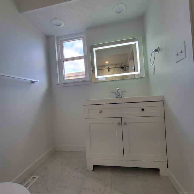 bathroom featuring a textured ceiling and vanity