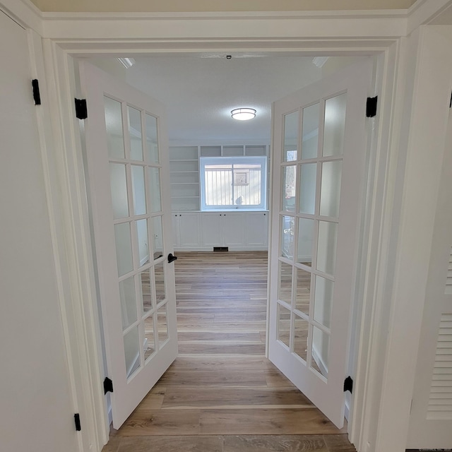 hallway featuring french doors and light hardwood / wood-style flooring