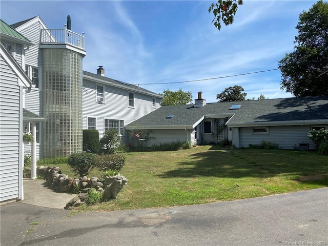 exterior space featuring a front yard and a balcony