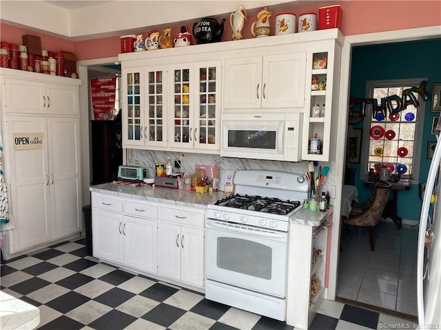 kitchen featuring white appliances and white cabinetry