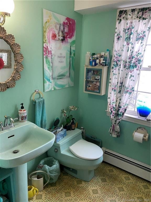 bathroom with tile patterned flooring, a baseboard radiator, and toilet