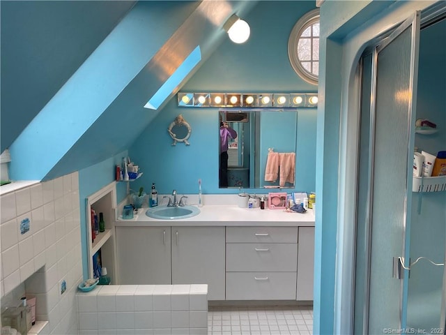 bathroom with vanity and lofted ceiling with skylight