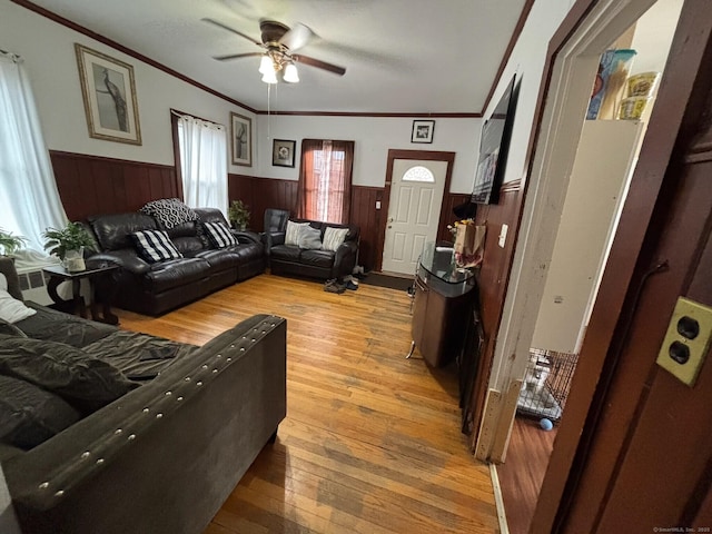 living room with wood-type flooring, ceiling fan, and crown molding