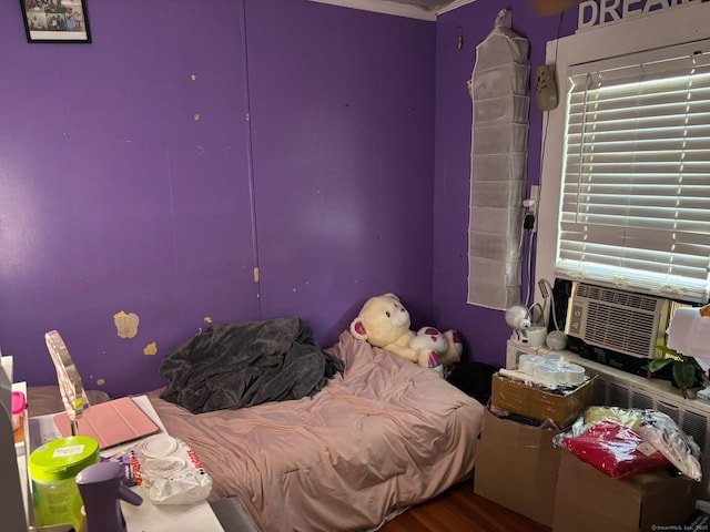 bedroom with cooling unit and wood-type flooring