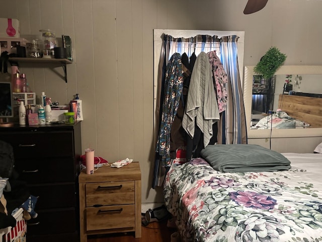 bedroom featuring wooden walls and ceiling fan