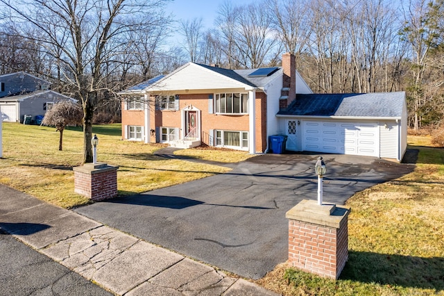 view of front of property featuring a front lawn and a garage