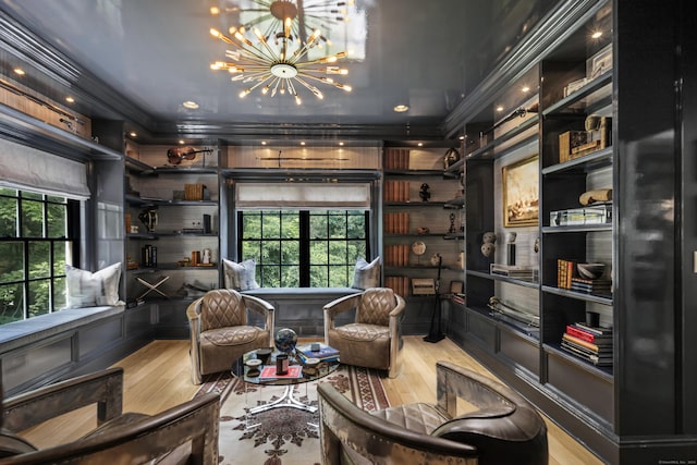 living area with built in shelves, light wood-type flooring, and an inviting chandelier