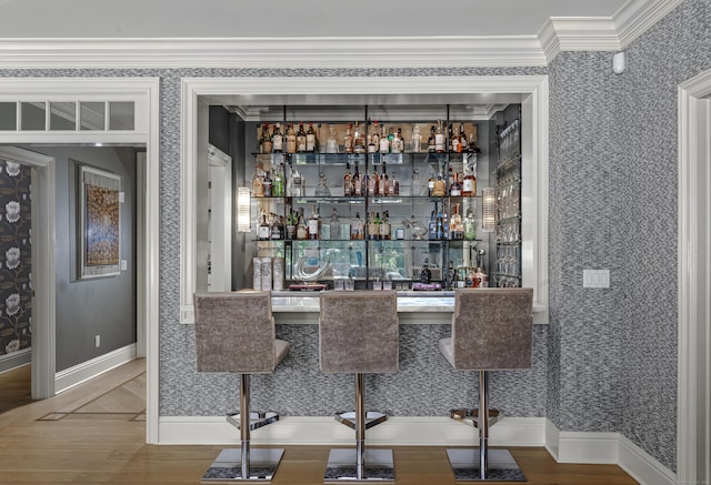 bar with hardwood / wood-style floors and ornamental molding