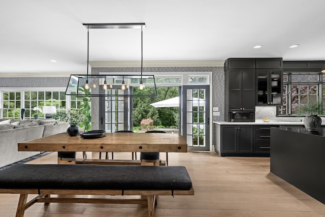 dining area featuring light hardwood / wood-style flooring, plenty of natural light, and crown molding