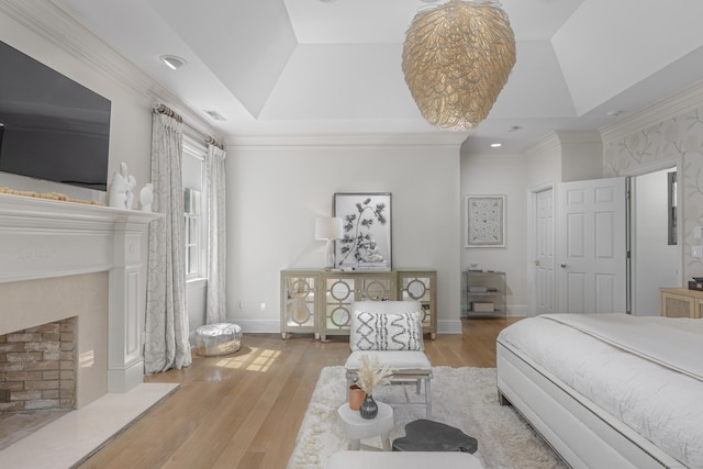 bedroom with a tray ceiling, crown molding, light hardwood / wood-style floors, and vaulted ceiling