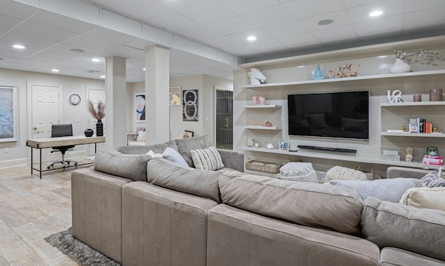 living room with a paneled ceiling and light hardwood / wood-style floors