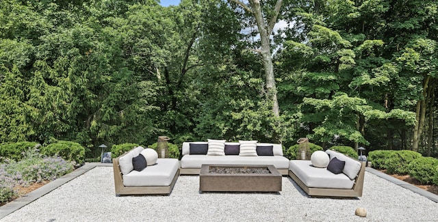 view of patio with an outdoor living space with a fire pit