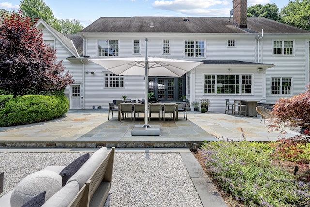 back of house with outdoor lounge area and a patio