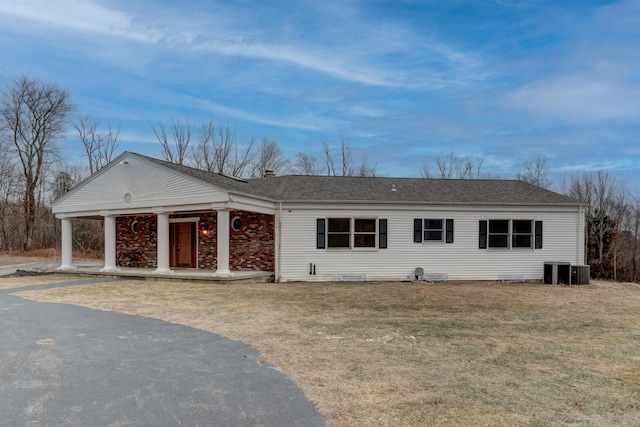 single story home with central air condition unit and a front lawn