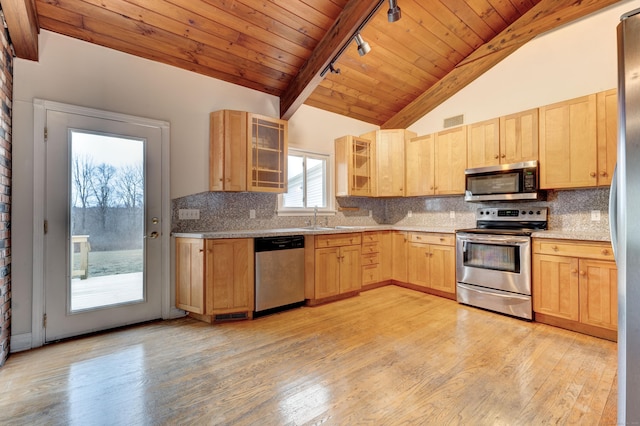 kitchen featuring decorative backsplash, light brown cabinetry, stainless steel appliances, and light hardwood / wood-style flooring