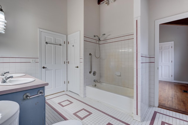 full bathroom with tile patterned floors, toilet, vanity, tile walls, and tiled shower / bath