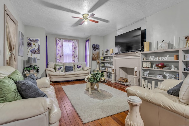 living room with ceiling fan, wood-type flooring, and a textured ceiling