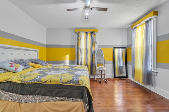 bedroom with ceiling fan, a textured ceiling, and hardwood / wood-style flooring