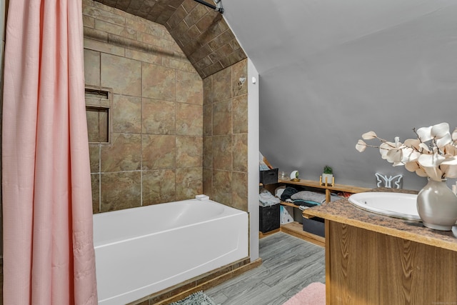 bathroom with hardwood / wood-style floors, shower / bath combination with curtain, lofted ceiling, and vanity