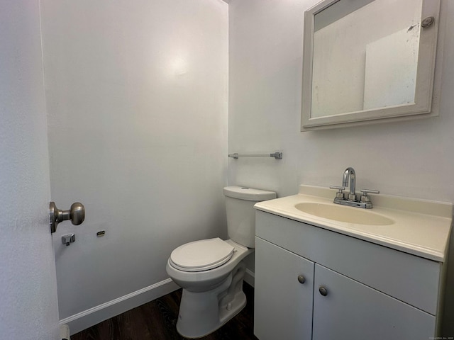 bathroom featuring wood-type flooring, vanity, and toilet