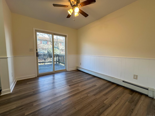 spare room featuring ceiling fan, dark hardwood / wood-style floors, and a baseboard heating unit