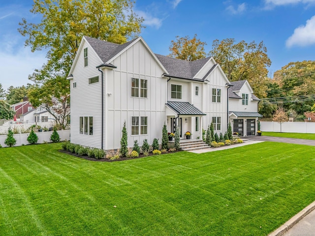 modern farmhouse style home with a standing seam roof, fence, board and batten siding, and roof with shingles