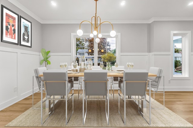 dining room featuring ornamental molding, a healthy amount of sunlight, and a decorative wall