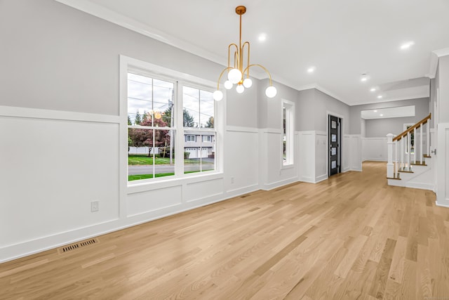 interior space featuring a decorative wall, visible vents, ornamental molding, stairway, and light wood-type flooring