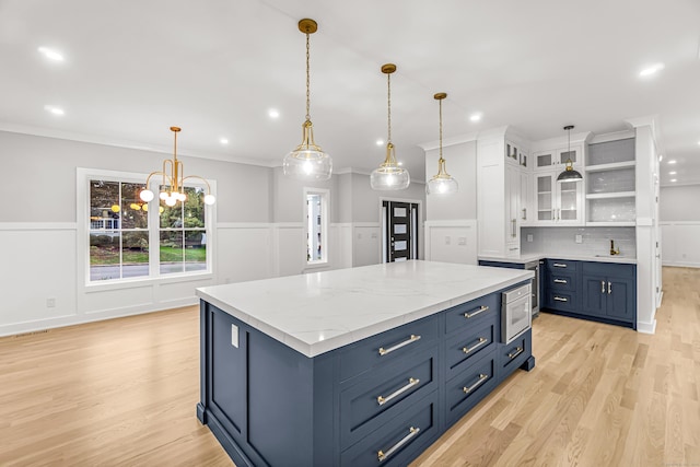 kitchen with light wood-style floors, a kitchen island, white cabinetry, and open shelves