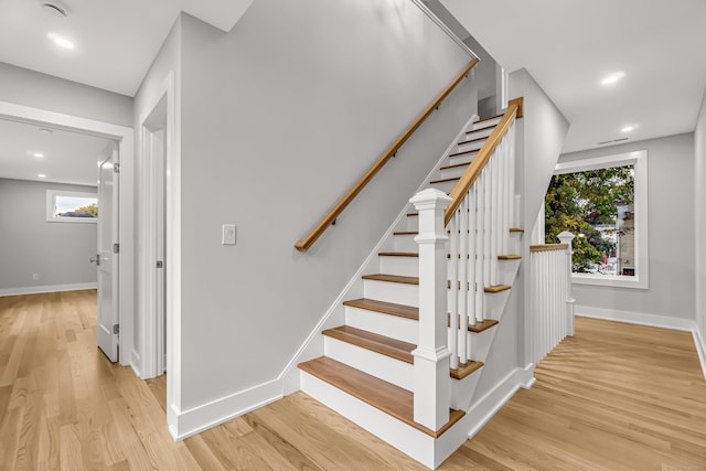 stairs with recessed lighting, wood finished floors, and baseboards