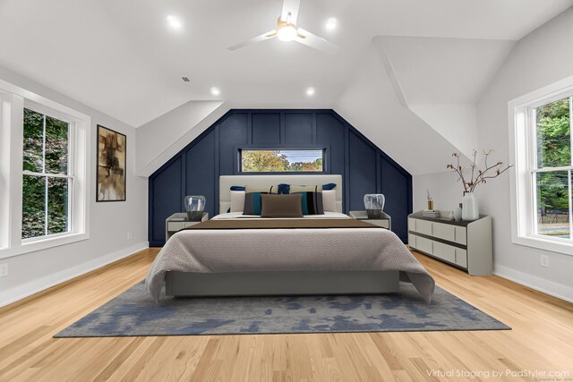 bedroom featuring light wood finished floors, baseboards, and vaulted ceiling