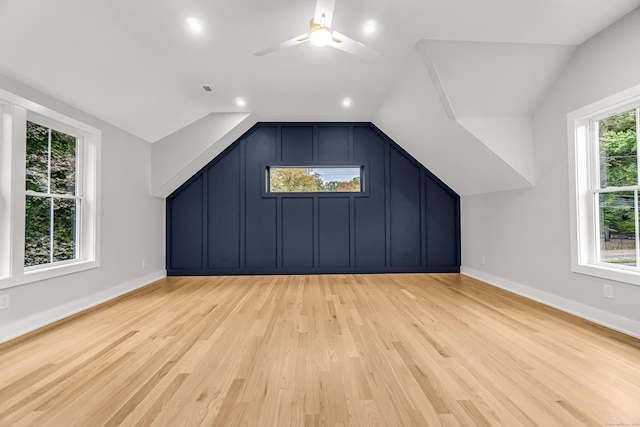 additional living space with vaulted ceiling, light wood-type flooring, and baseboards