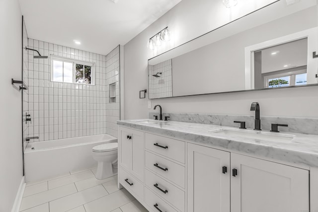 bathroom featuring shower / bathtub combination, double vanity, a sink, and toilet