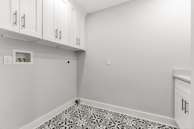 laundry area with washer hookup, cabinet space, electric dryer hookup, tile patterned flooring, and baseboards