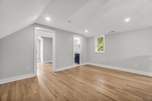 interior space with lofted ceiling, light wood-style floors, baseboards, and recessed lighting