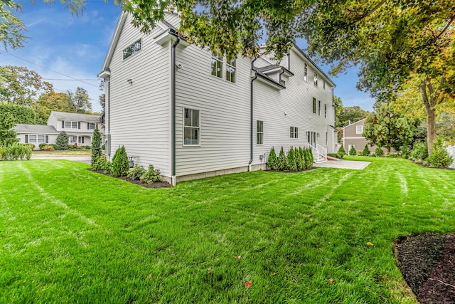 rear view of house featuring entry steps and a yard